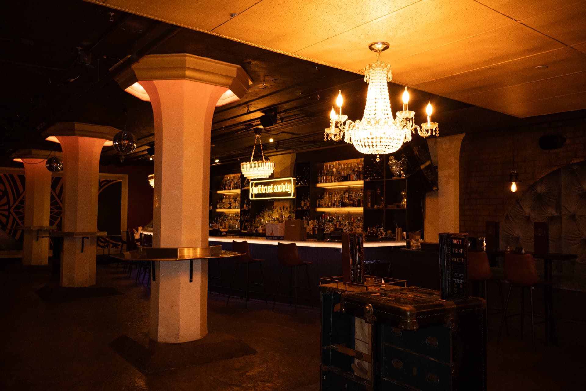 Society's full speakeasy with crystal chandeliers, gold-trimmed columns and the neon sign above the bar